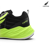 Close-up side view of a Carino running shoe in black and neon yellow-green, showing the heel and midsole on a white background with the Carino logo in the top right.